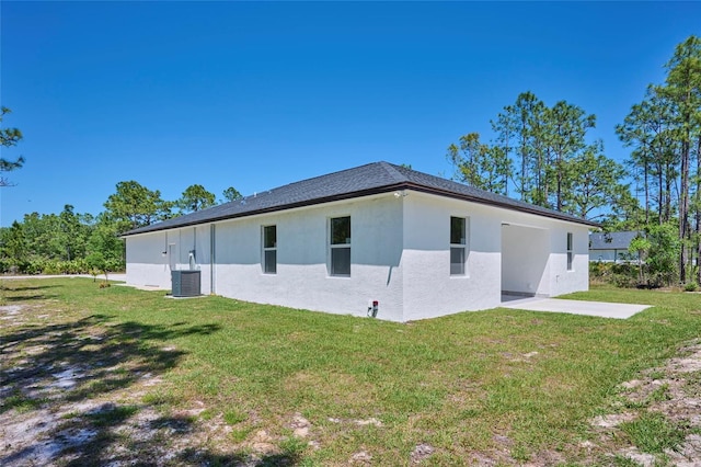 rear view of property featuring a patio, central AC, and a lawn