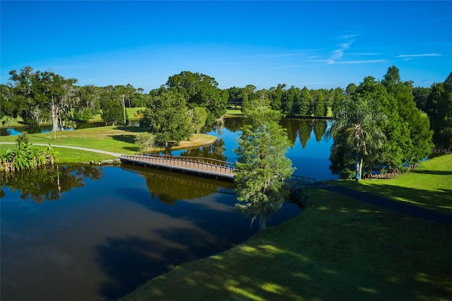 surrounding community featuring a water view and a lawn