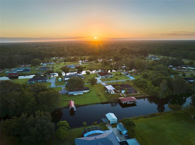 aerial view at dusk featuring a water view