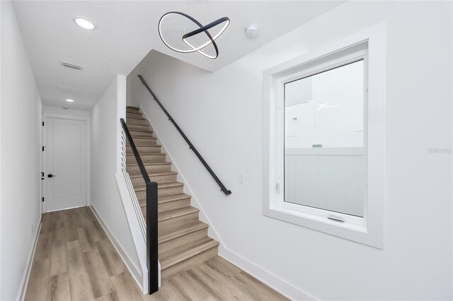 staircase with hardwood / wood-style flooring