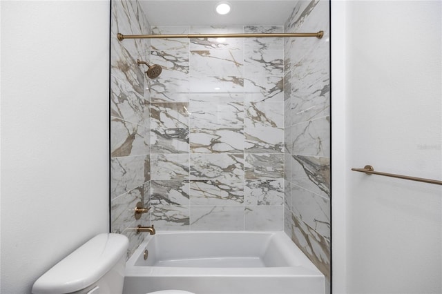 bathroom featuring toilet and tiled shower / bath