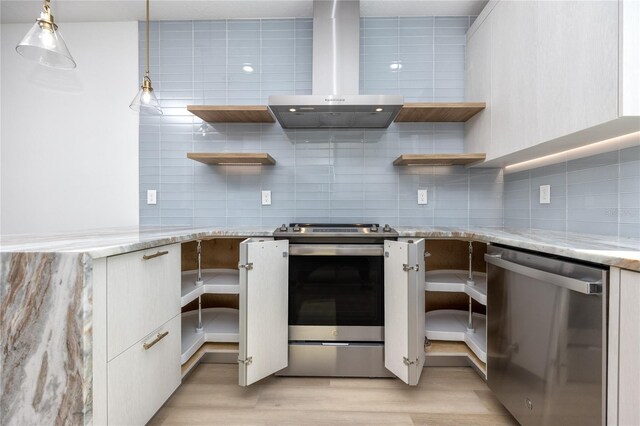 kitchen featuring hanging light fixtures, wall chimney range hood, tasteful backsplash, light hardwood / wood-style flooring, and appliances with stainless steel finishes