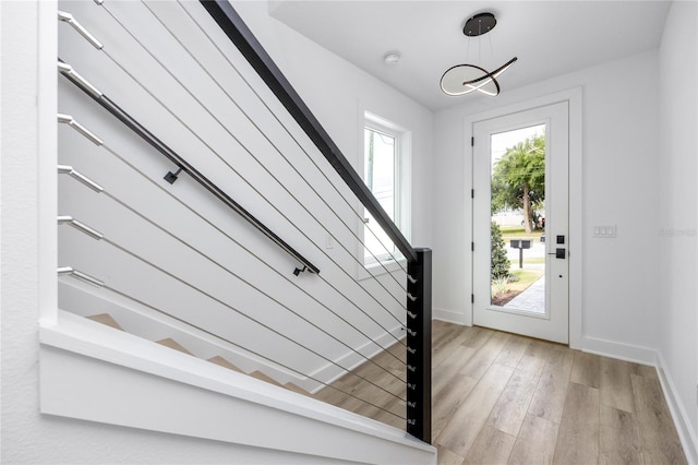 entrance foyer featuring light wood-type flooring and a notable chandelier