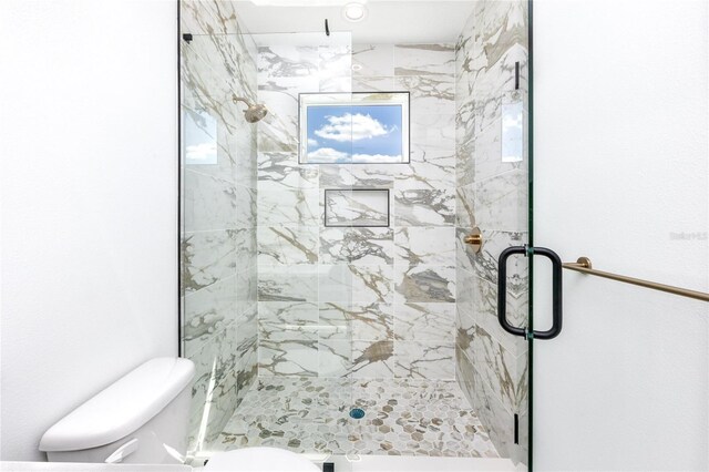 bathroom featuring walk in shower and toilet