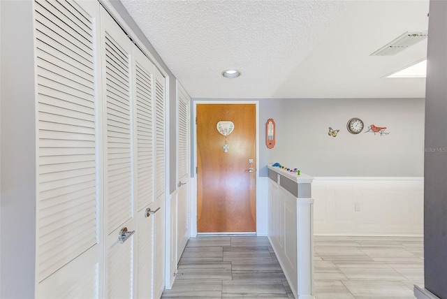 hall with a textured ceiling