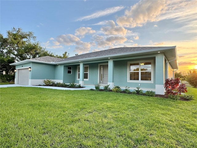 ranch-style home with a garage and a lawn