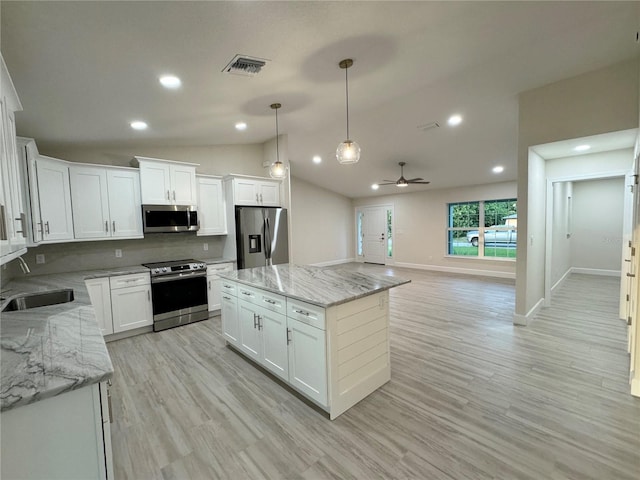 kitchen featuring white cabinetry, stainless steel appliances, light hardwood / wood-style flooring, a center island, and sink