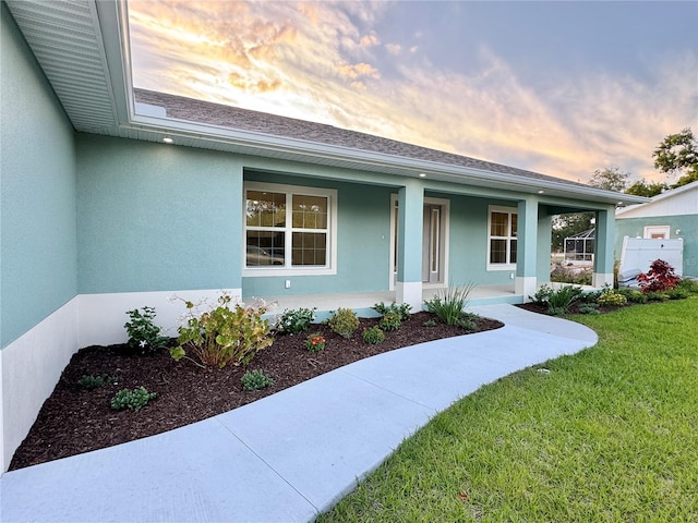 view of front of house featuring covered porch and a yard