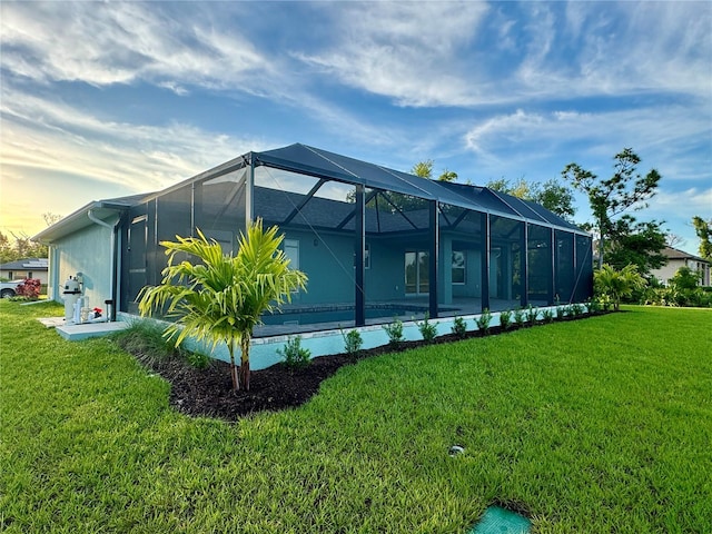 view of home's exterior featuring glass enclosure and a lawn