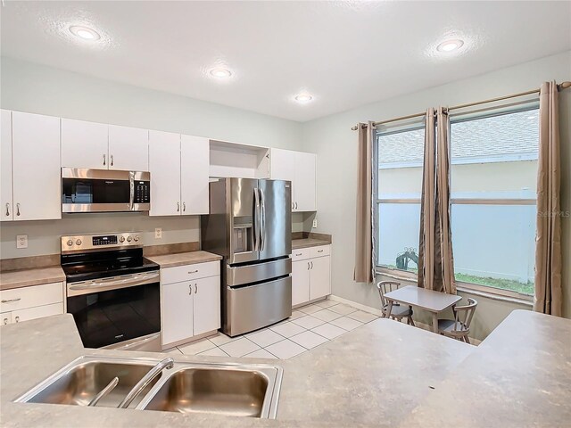 kitchen with sink, appliances with stainless steel finishes, and white cabinetry