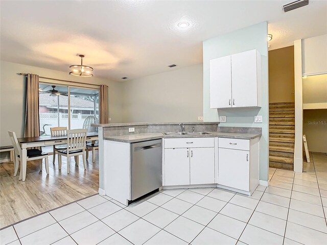 kitchen featuring decorative light fixtures, white cabinetry, sink, light tile floors, and stainless steel dishwasher