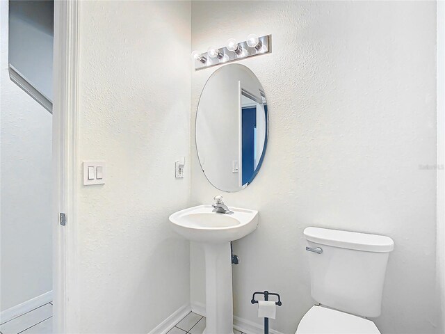 bathroom featuring toilet and tile flooring