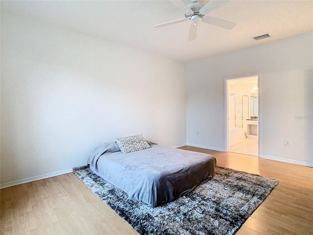 bedroom with light hardwood / wood-style flooring, connected bathroom, and ceiling fan