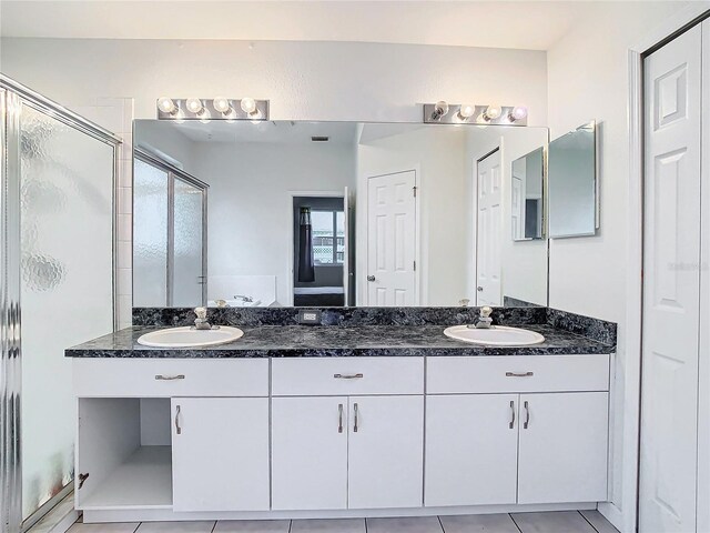 bathroom with a wealth of natural light, tile floors, and dual vanity