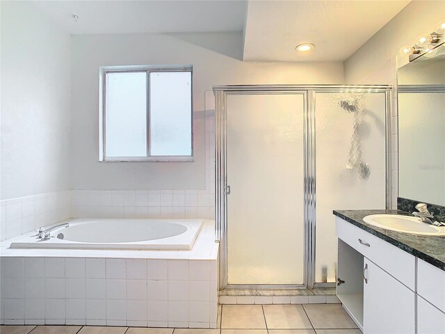 bathroom featuring vanity with extensive cabinet space, shower with separate bathtub, and tile floors