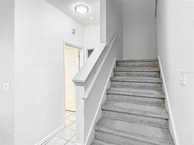 stairway featuring light tile floors