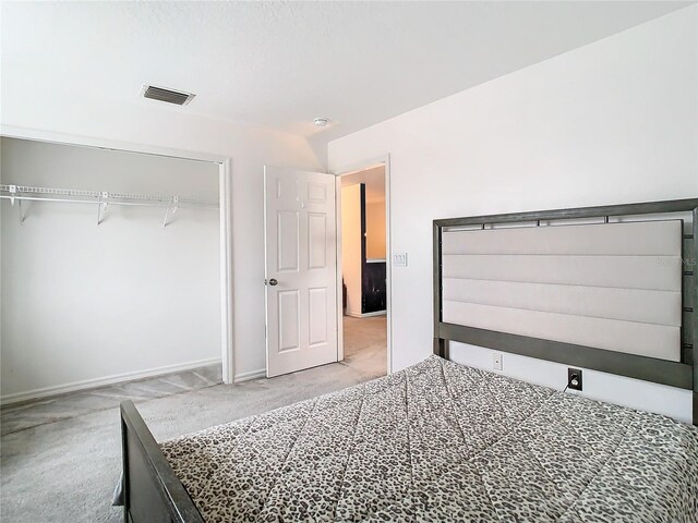 bedroom featuring light colored carpet and a closet