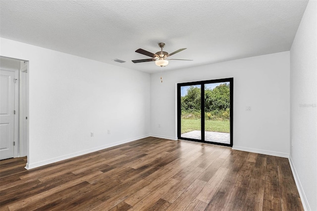 empty room featuring dark wood-type flooring, ceiling fan, and a textured ceiling