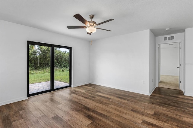 empty room with ceiling fan and dark hardwood / wood-style flooring