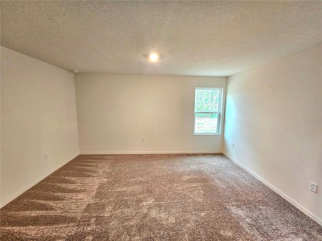 carpeted empty room with a textured ceiling