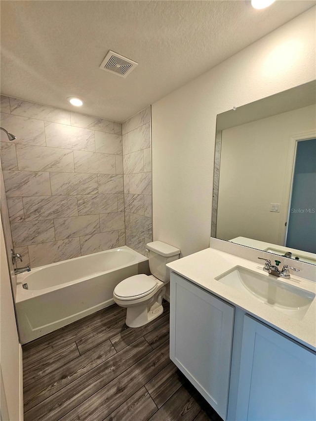 full bathroom featuring tiled shower / bath combo, vanity with extensive cabinet space, and toilet