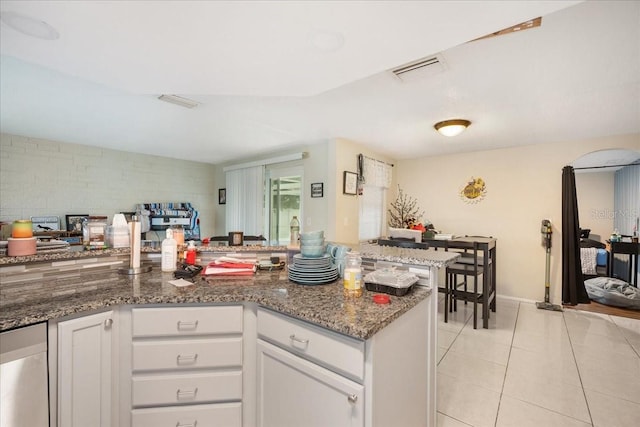 kitchen with white cabinets, dark stone countertops, and light tile floors