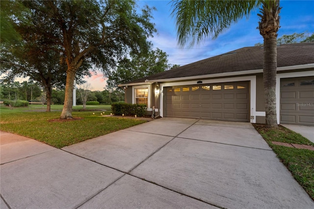 view of front of home with a yard and a garage