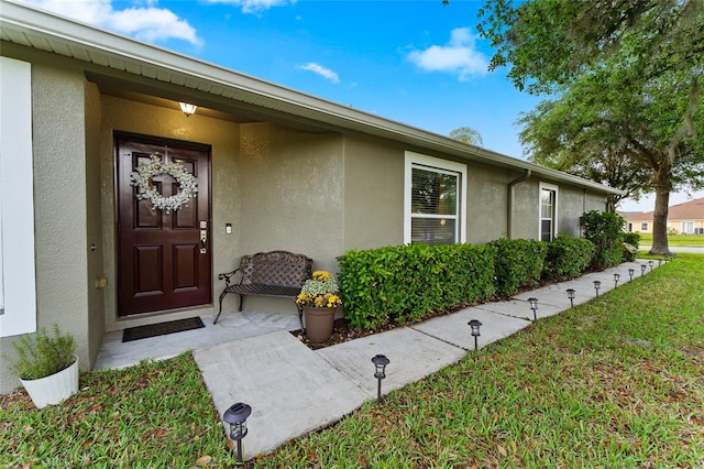 doorway to property featuring a yard