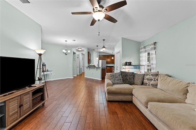 living room with ceiling fan with notable chandelier and dark hardwood / wood-style flooring