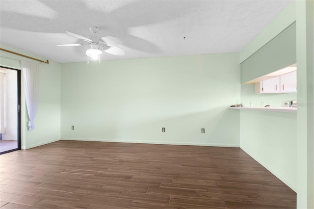 empty room with dark hardwood / wood-style flooring, ceiling fan, and a textured ceiling