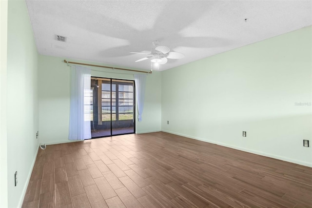 empty room featuring dark wood-type flooring, ceiling fan, and a textured ceiling