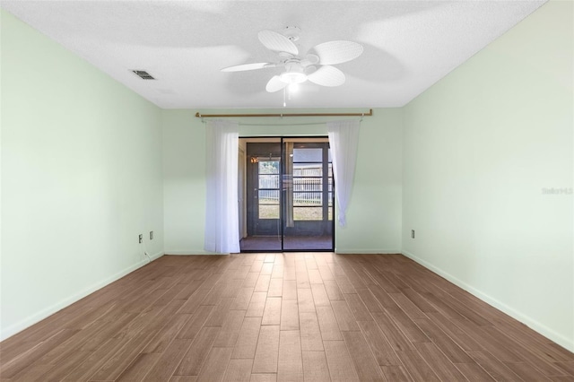 empty room featuring ceiling fan, a textured ceiling, french doors, and dark hardwood / wood-style flooring