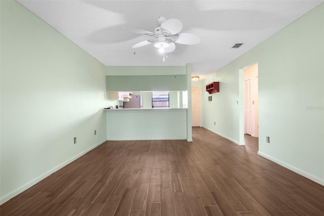 spare room featuring dark wood-type flooring, ceiling fan, and a textured ceiling