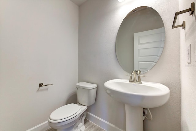 bathroom with hardwood / wood-style flooring, sink, and toilet