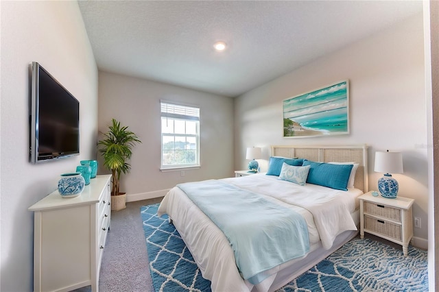 bedroom featuring a textured ceiling and dark carpet