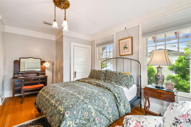 bedroom with hardwood / wood-style flooring and crown molding