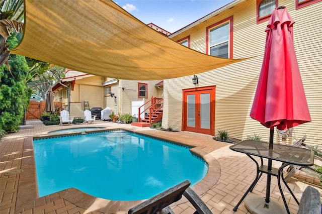 view of swimming pool featuring a patio area and french doors