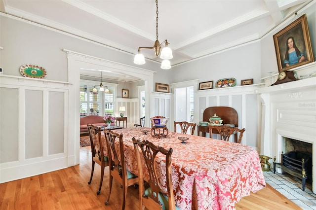 dining area featuring hardwood / wood-style floors, an inviting chandelier, ornamental molding, coffered ceiling, and beam ceiling