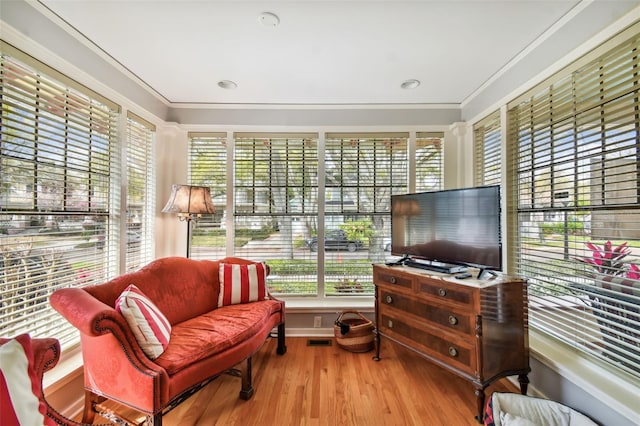 sitting room featuring crown molding, a healthy amount of sunlight, and light wood-type flooring