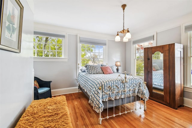 bedroom with a notable chandelier and hardwood / wood-style flooring