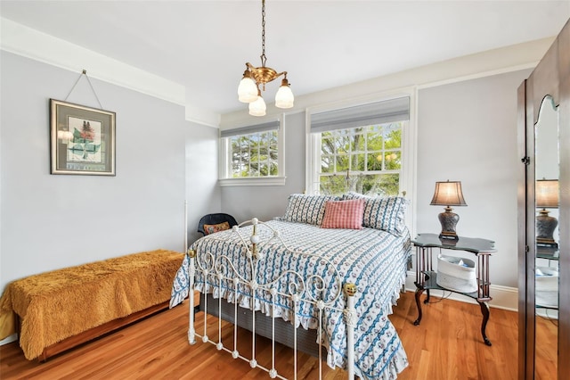 bedroom featuring wood-type flooring and an inviting chandelier