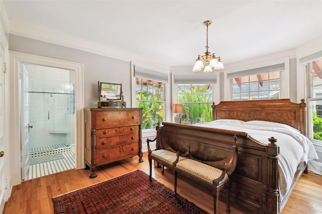 bedroom with connected bathroom, a notable chandelier, and light hardwood / wood-style floors