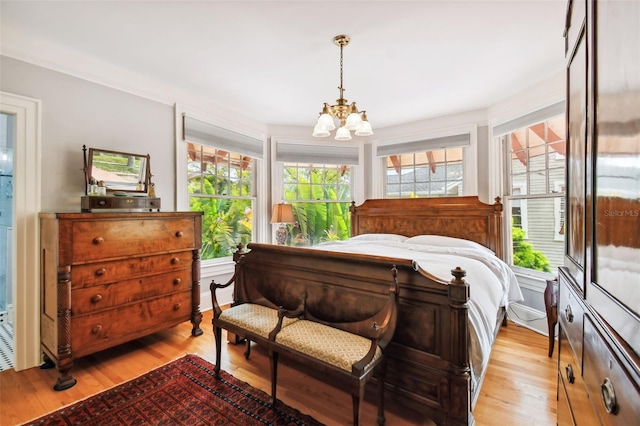 bedroom with a chandelier and light wood-type flooring