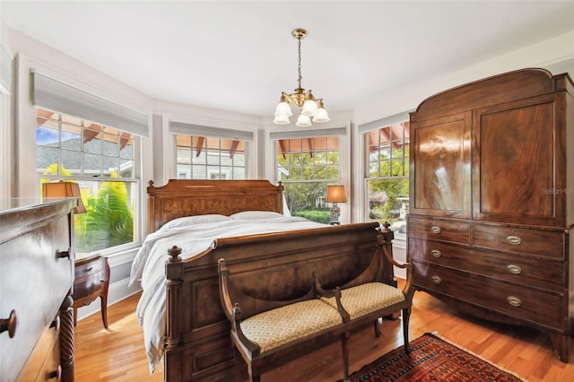 bedroom featuring light hardwood / wood-style flooring and a chandelier