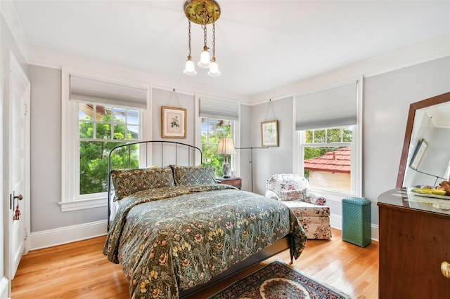 bedroom with multiple windows and light hardwood / wood-style floors