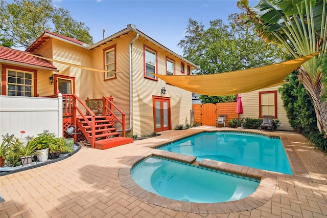 rear view of house with a fenced in pool, a patio, and french doors