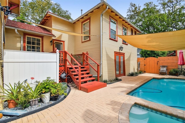 back of house featuring french doors, a fenced in pool, and a patio