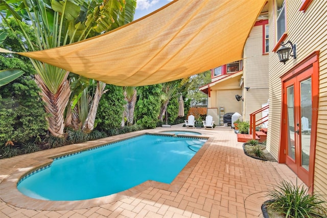 view of swimming pool with grilling area, a patio, an in ground hot tub, and french doors