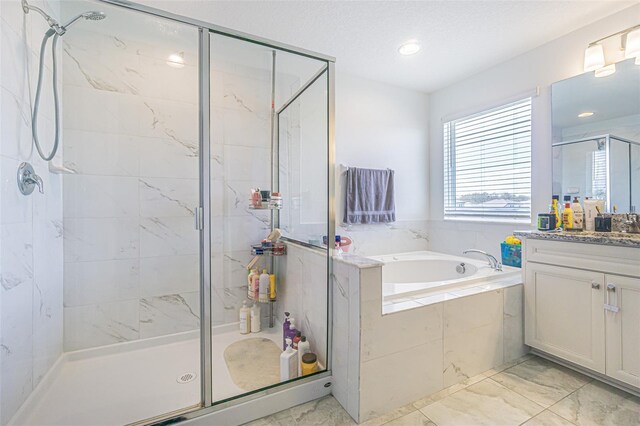 bathroom featuring separate shower and tub, vanity, and a textured ceiling