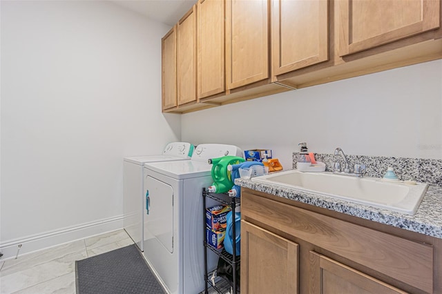 laundry area featuring cabinets, washing machine and dryer, and sink